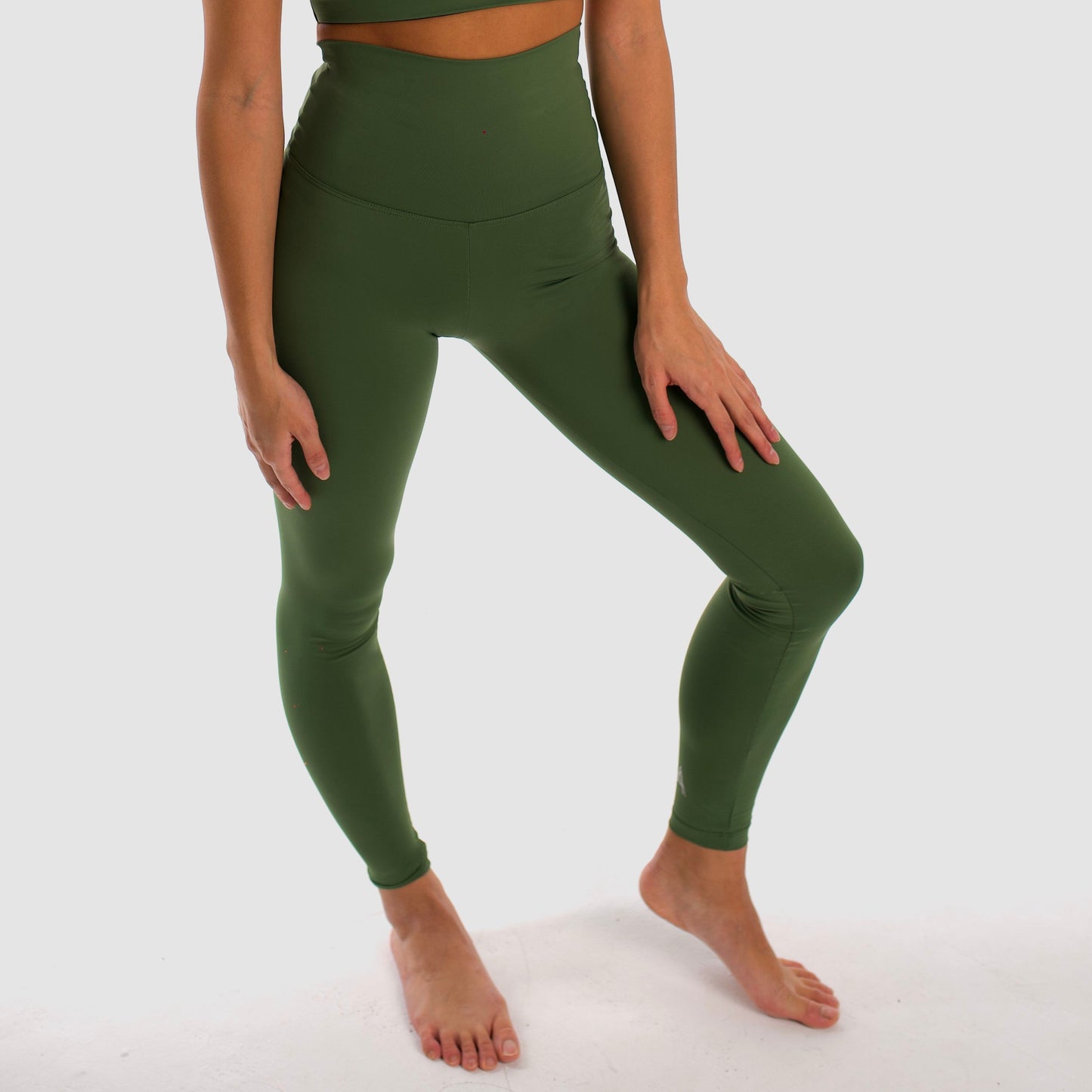 Olive green high-waisted sports leggings. Compression effect. Comfortable and resistant. Pocket to put your essentials. Mallas de deporte de tiro alto de color verde oliva. Efecto compresivo. Cómodo y resistente. Bolsillo trasero para meter lo esencial. 