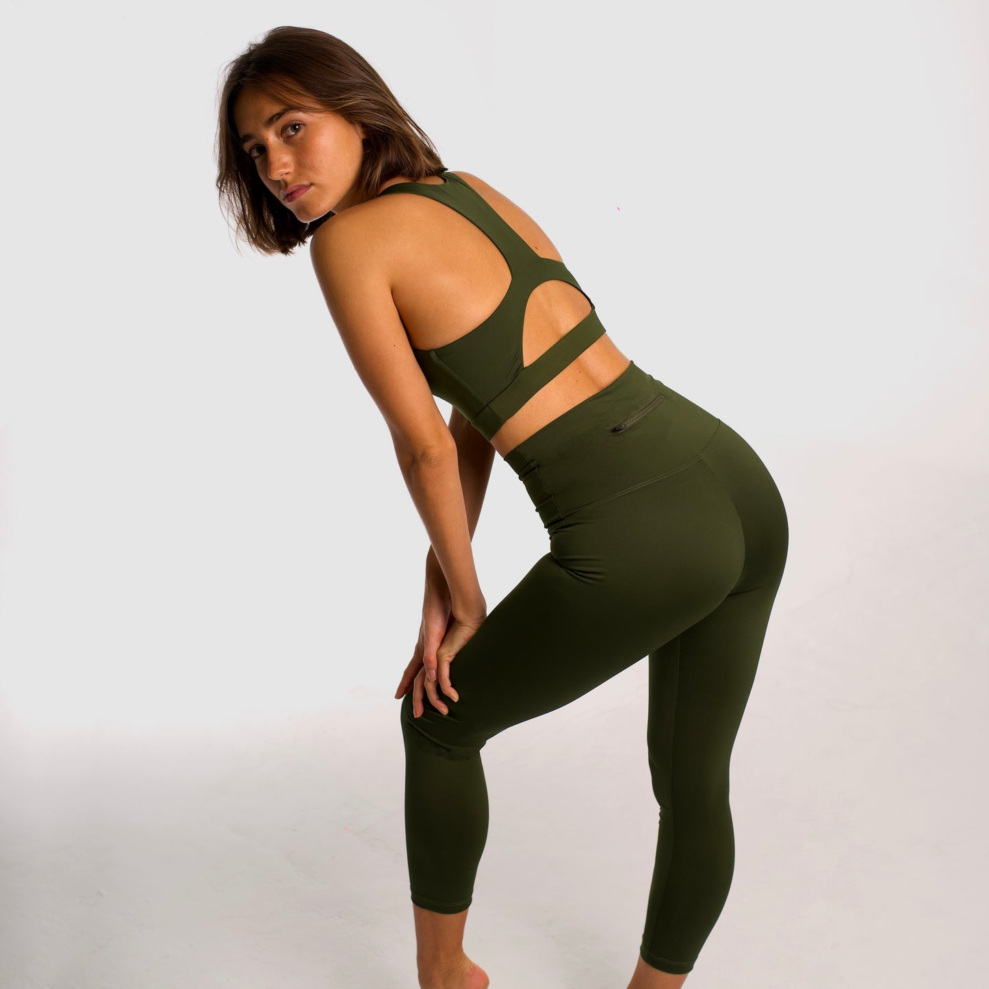 Women's khaki sports top. Long cut bra. Elastic chest strap for comfort and support. Lightweight, breathable and comfortable bra. Removable cups. Top deportivo de mujer color khaki. Sujetador de corte largo. Tira elástica en el pecho ofreciendo comodidad y sujeción. Sujetador cómo, ligero y transpirable. Top con copas extraibles. 