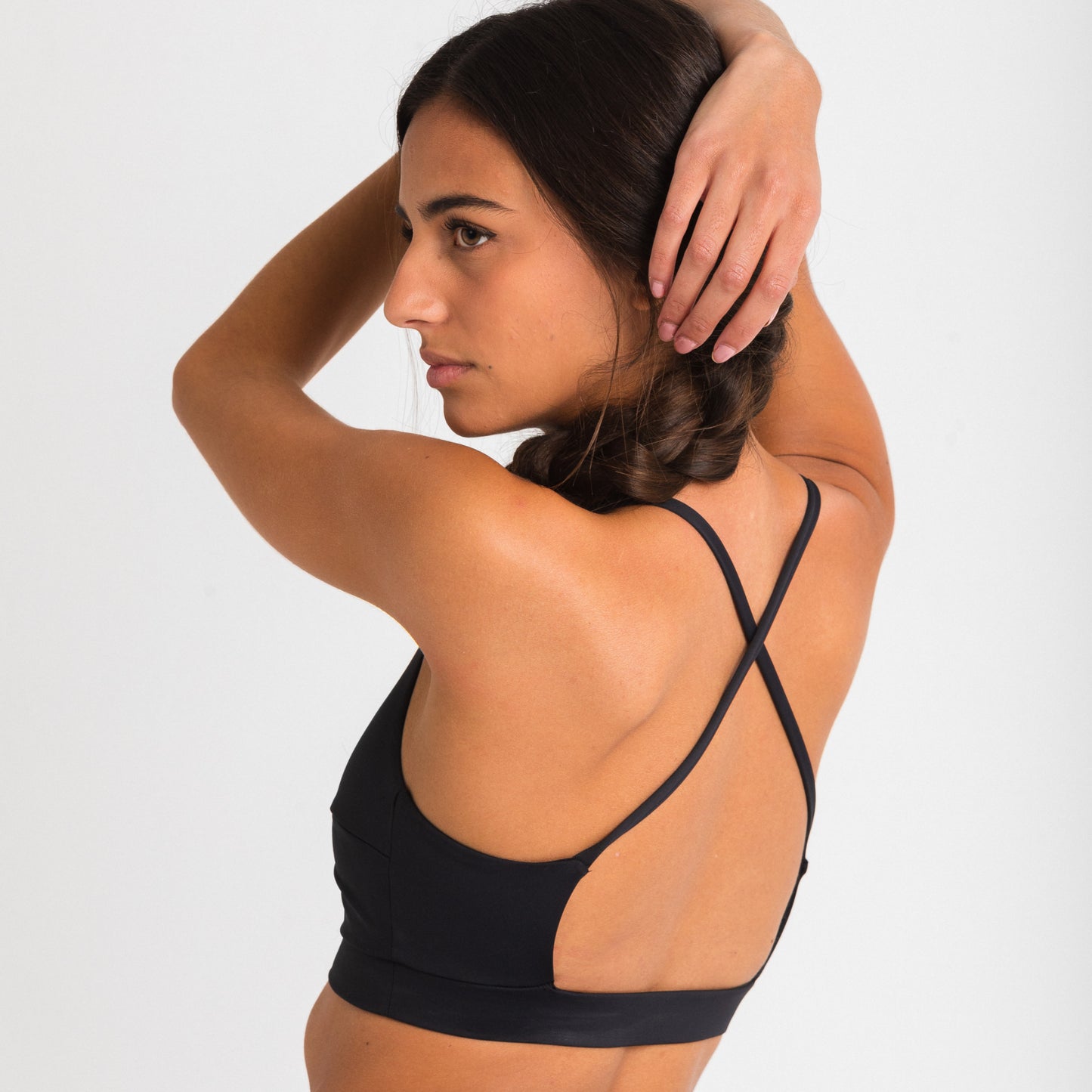 Women's black sports top. Cross-strap bra. Elastic chest strap for comfort and support. Lightweight, breathable and comfortable bra. Removable cups. Top Deportivo mujer negro. Sujetador de tirantes cruzados. Tira elástica en el pecho ofreciendo comodidad y sujeción. Sujetador cómo, ligero y transpirable. Top con copas extraibles. 