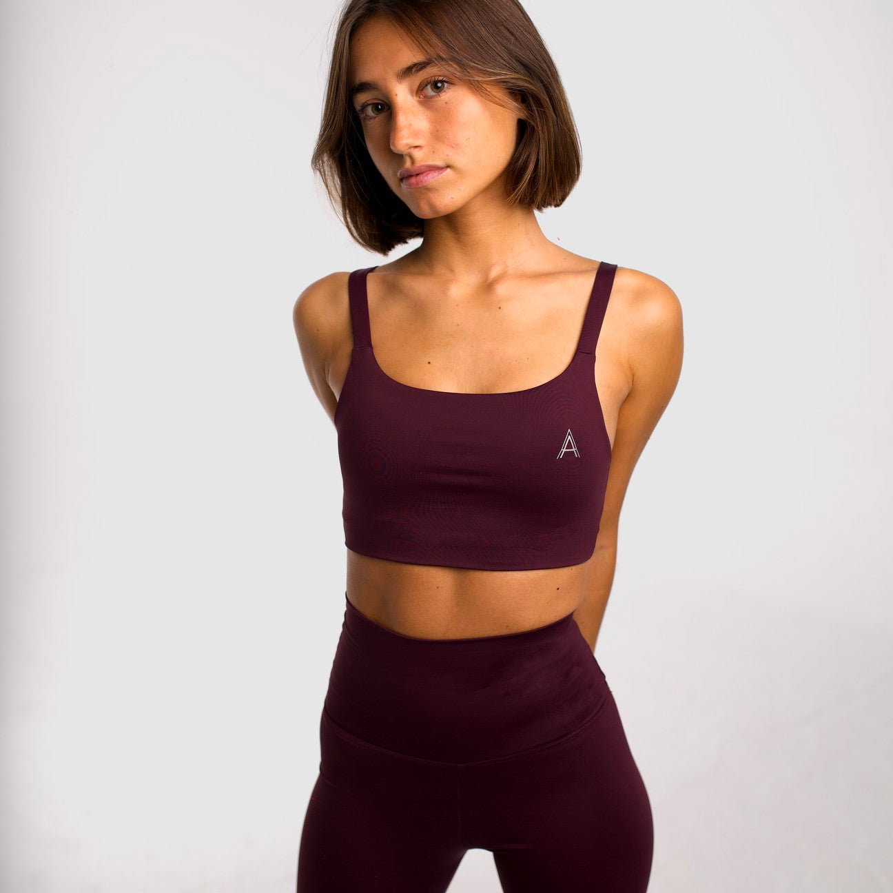 Women's purple sports top. Cross-strap bra. Elastic chest strap for comfort and support. Lightweight, breathable and comfortable bra. Removable cups. Top deportivo de mujer morado. Sujetador de tirantes cruzados. Tira elástica en el pecho ofreciendo comodidad y sujeción. Sujetador cómo, ligero y transpirable. Top con copas extraibles.