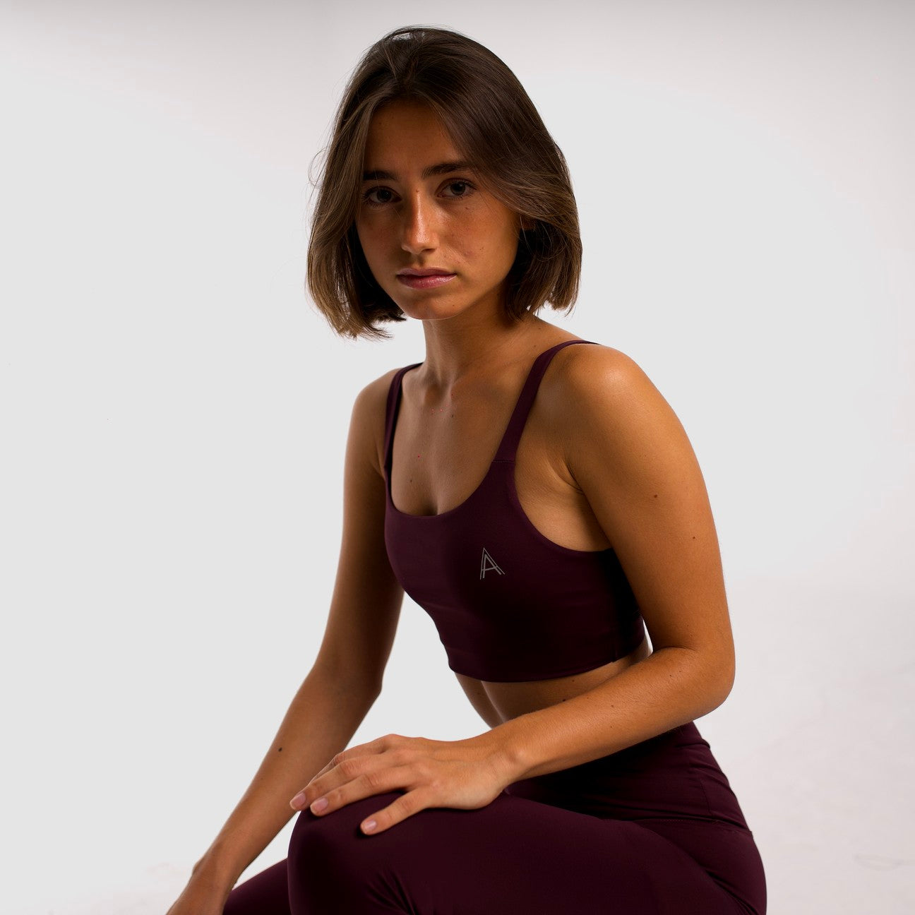 Women's purple sports top. Cross-strap bra. Elastic chest strap for comfort and support. Lightweight, breathable and comfortable bra. Removable cups. Top deportivo de mujer morado. Sujetador de tirantes cruzados. Tira elástica en el pecho ofreciendo comodidad y sujeción. Sujetador cómo, ligero y transpirable. Top con copas extraibles.