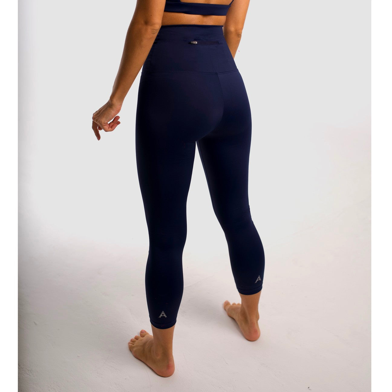 Navy blue high-waisted sports leggings. Compression effect. 7/8 length leggings Comfortable and resistant. Pocket to put your essentials. Mallas de deporte de tiro alto de color azul marino. Efecto compresivo. Cómodo y resistente. Bolsillo trasero para meter lo esencial.