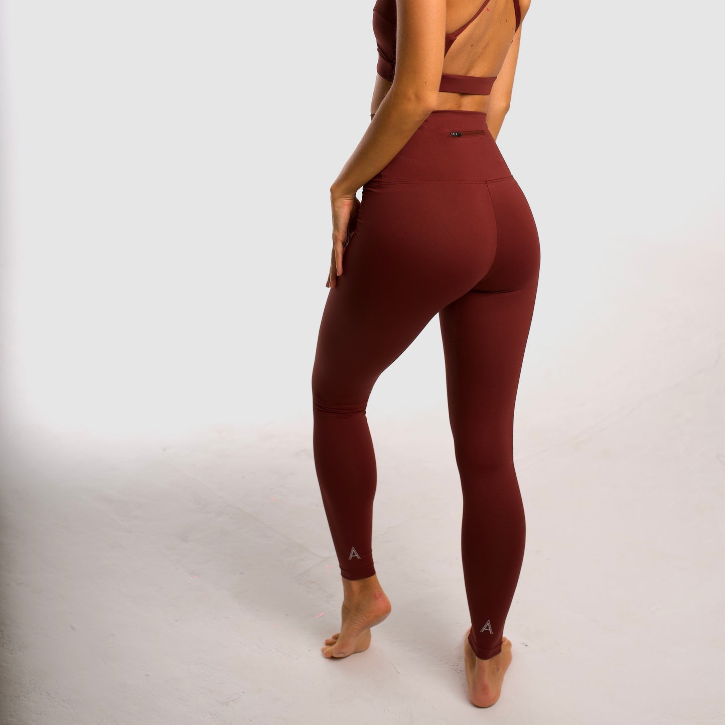 Maroon high-waisted sports leggings. Compression effect. Comfortable and resistant. Pocket to put your essentials. Mallas de deporte de tiro alto de color granate. Efecto compresivo. Cómodo y resistente. Bolsillo trasero para meter lo esencial. 