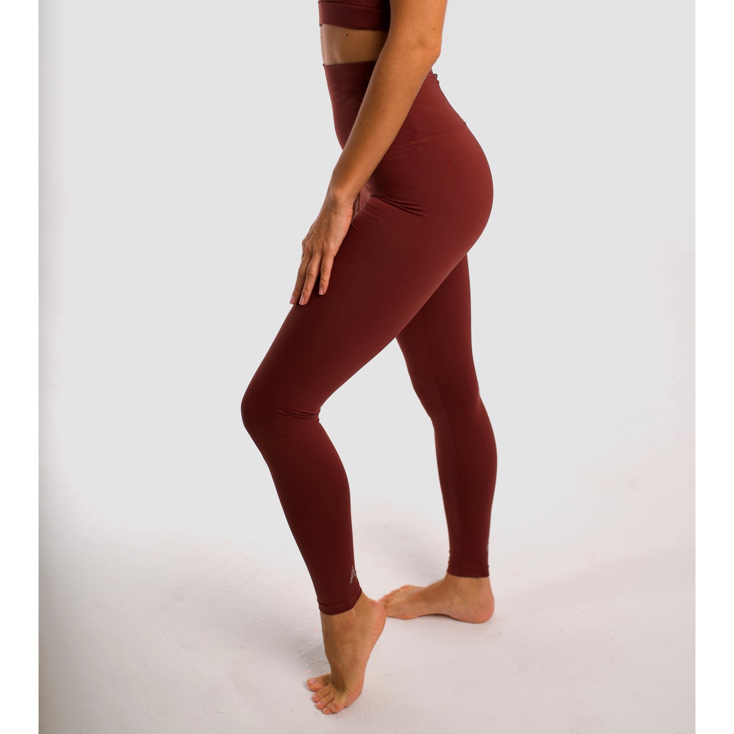 Maroon high-waisted sports leggings. Compression effect. Comfortable and resistant. Pocket to put your essentials. Mallas de deporte de tiro alto de color granate. Efecto compresivo. Cómodo y resistente. Bolsillo trasero para meter lo esencial. 