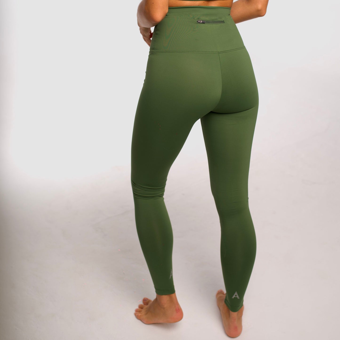 Olive green high-waisted sports leggings. Compression effect. Comfortable and resistant. Pocket to put your essentials. Mallas de deporte de tiro alto de color verde oliva. Efecto compresivo. Cómodo y resistente. Bolsillo trasero para meter lo esencial. 