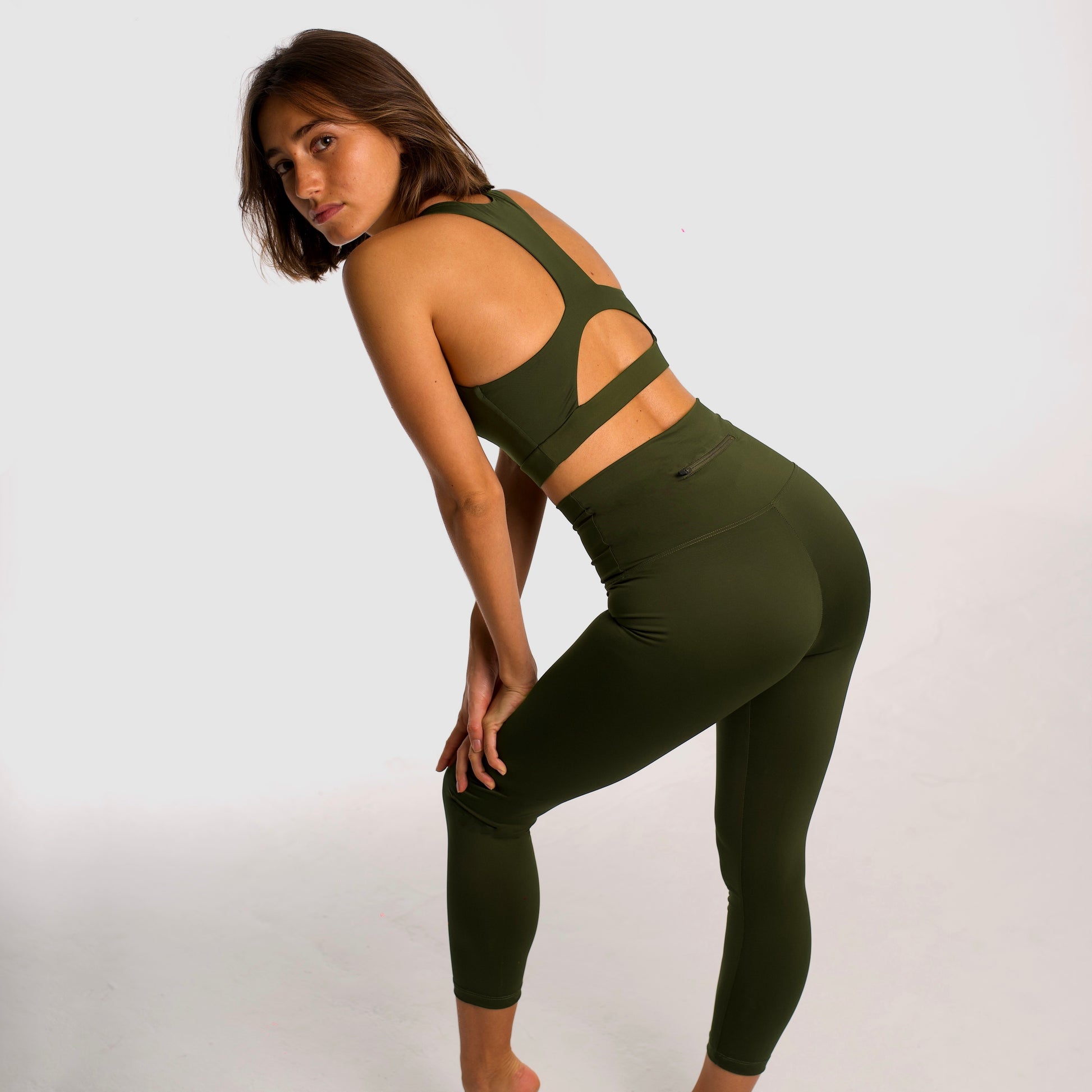 Women's khaki sports top. Long cut bra. Elastic chest strap for comfort and support. Lightweight, breathable and comfortable bra. Removable cups. Top deportivo de mujer color khaki. Sujetador de corte largo. Tira elástica en el pecho ofreciendo comodidad y sujeción. Sujetador cómo, ligero y transpirable. Top con copas extraibles. 