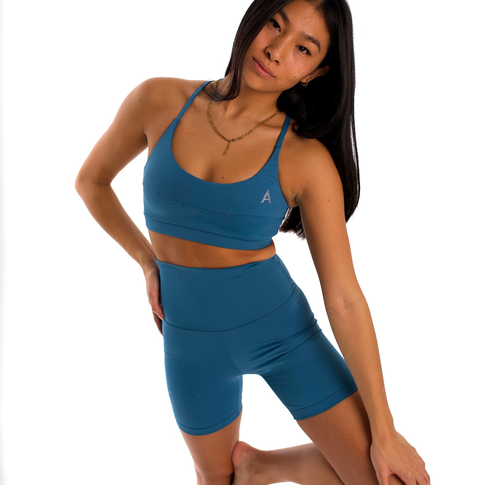 Women's canard blue sports bra. Cross-strap bra. Lightweight, breathable and comfortable bra. Removable cups. Top Deportivo mujer azul pato. Sujetador de tirantes cruzados. Tira elástica en el pecho ofreciendo comodidad y sujeción. Sujetador cómodo, ligero y transpirable. Top con copas extraíbles. 