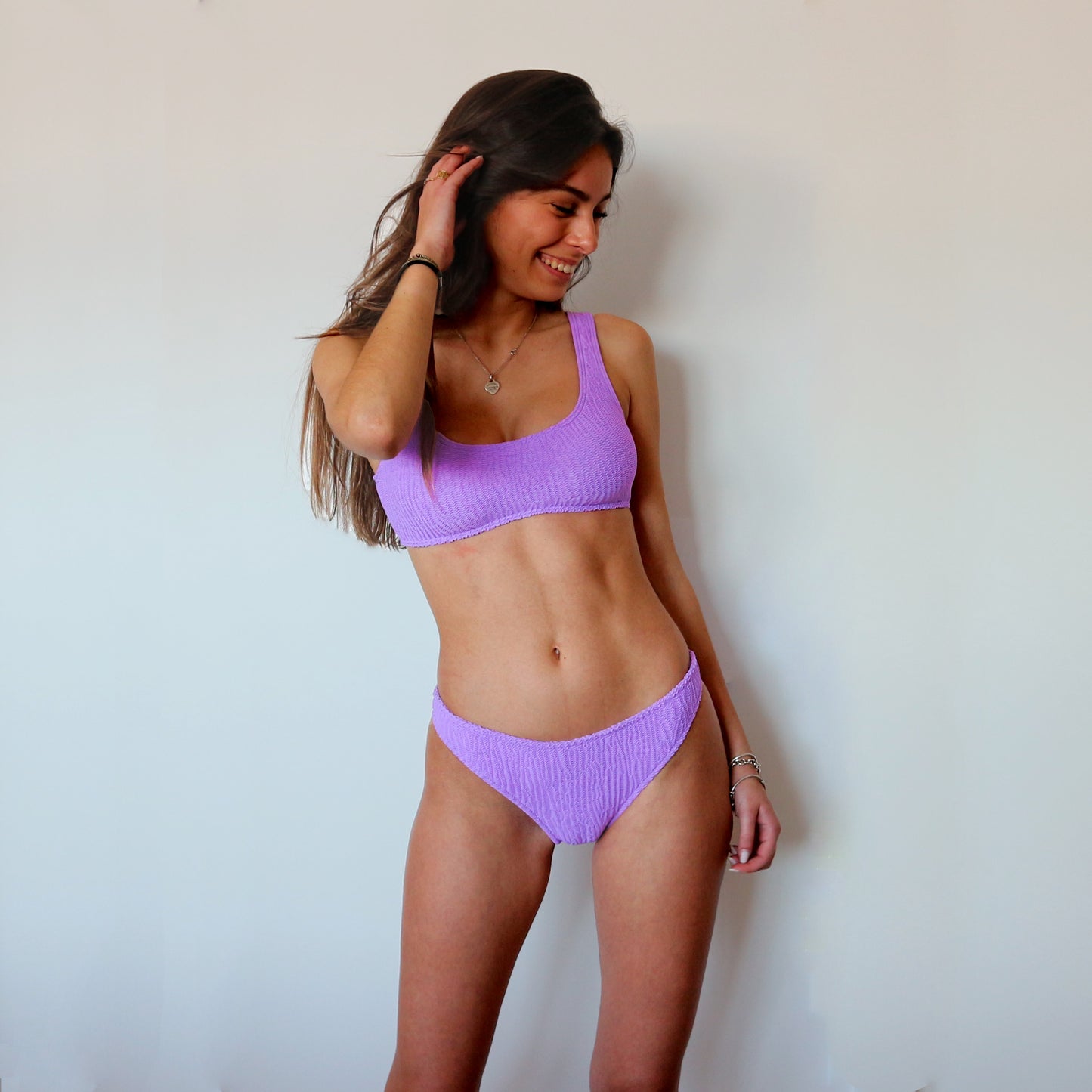Cropped lilac bikini top. Textured finish and wide shoulder straps. This bikini will never upset you, it will always be one of your favorites. Top de bikini lila. Crop top con tirantes gruesos. Este bikini siempre será de tus favoritos.