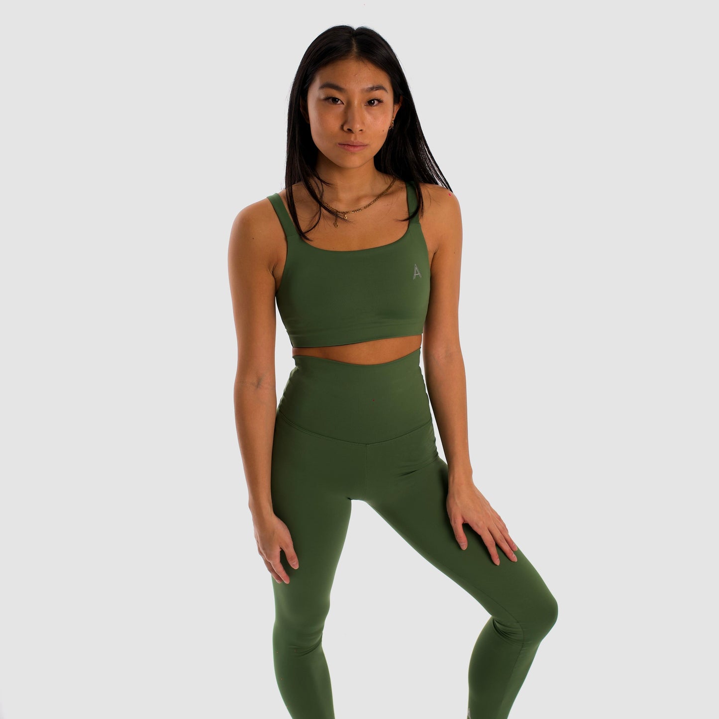 Women's olive green sports bra. Cross-strap bra. Lightweight, breathable and comfortable bra. Removable cups. Top deportivo de mujer verde oliva. Sujetador de tirantes cruzados. Tira elástica en el pecho ofreciendo comodidad y sujeción. Sujetador cómodo, ligero y transpirable. Top con copas extraíbles. 