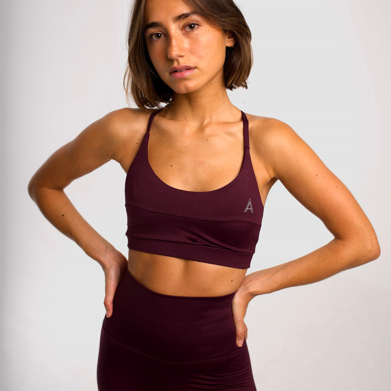 Women's purple sports top. Cross-strap bra. Elastic chest strap for comfort and support. Lightweight, breathable and comfortable bra. Removable cups. Top Deportivo mujer color morado. Sujetador de tirantes cruzados. Tira elástica en el pecho ofreciendo comodidad y sujeción. Sujetador cómo, ligero y transpirable. Top con copas extraibles. 