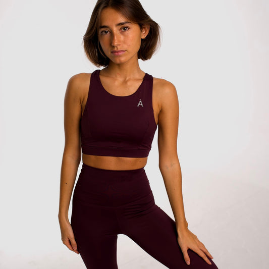 Women's purple sports top. Long cut bra. Elastic chest strap for comfort and support. Lightweight, breathable and comfortable bra. Removable cups. Top deportivo de mujer color morado. Sujetador de corte largo. Tira elástica en el pecho ofreciendo comodidad y sujeción. Sujetador cómo, ligero y transpirable. Top con copas extraibles. 