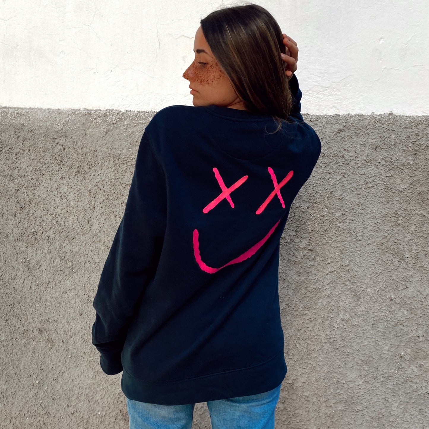 Sudadera azul oscuro con bordado rosa fosforito "happy face" en la parte trasera. Sudadera oversize diseñada en España. Algodón orgánico.Sudadera unisex sin capucha.Navy sweatshirt with fuchsia "happy face" embroidery on the back. Oversize sweatshirt designed in Spain. Organic cotton. unisex sweatshirt without hood.